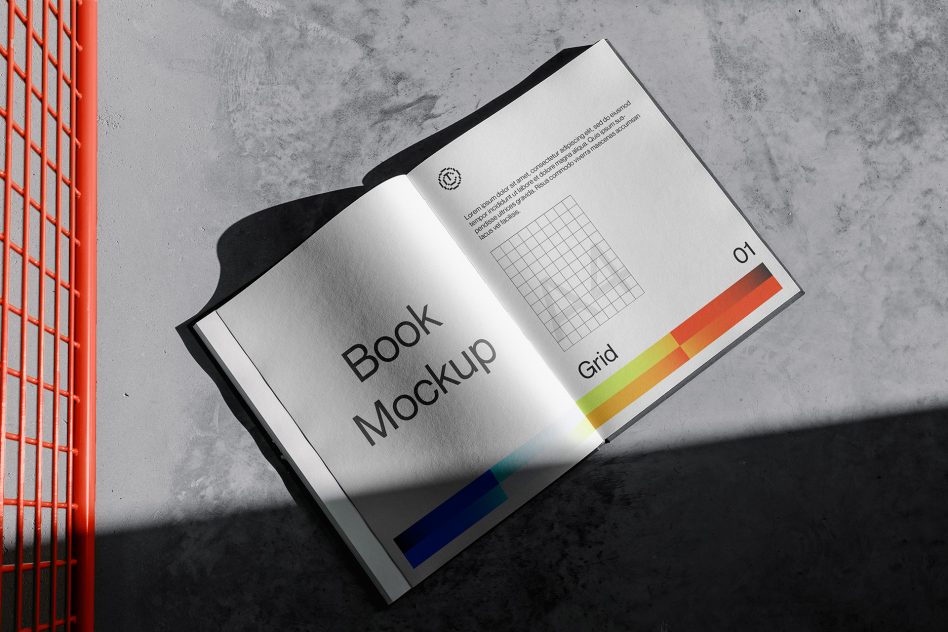 Open book mockup on a concrete surface with colorful grid design cast in natural light, ideal for presentation, graphic design.